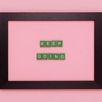 A framed motivational quote on a pink background for inspiration.