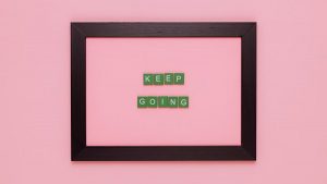 A framed motivational quote on a pink background for inspiration.